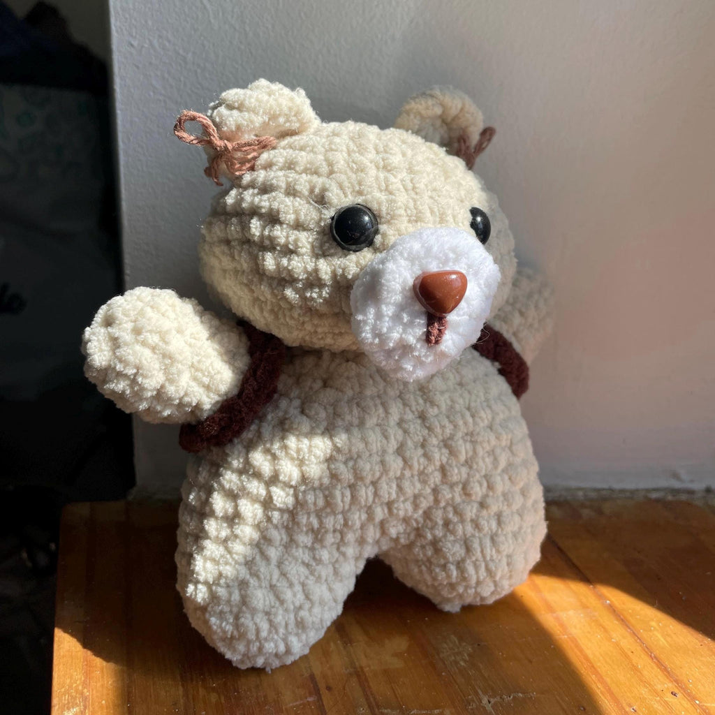 Ourson amigurumi au crochet fait main – marron et beige, sac à dos et petits nœuds dans les oreilles