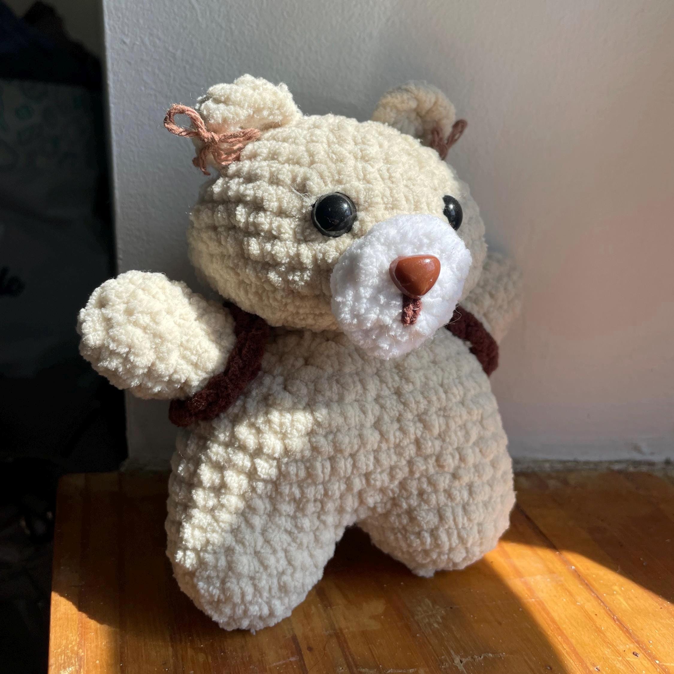 Ourson amigurumi au crochet fait main – marron et beige, sac à dos et petits nœuds dans les oreilles