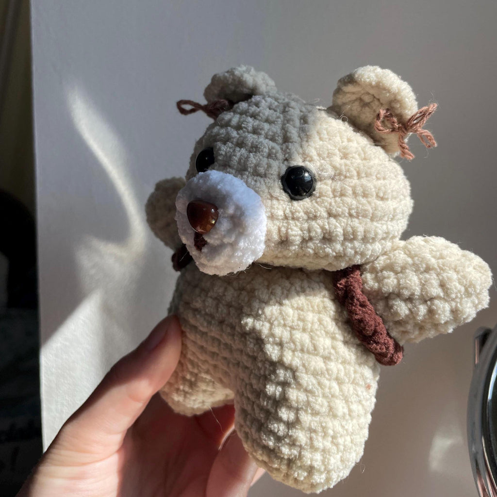 Ourson amigurumi au crochet fait main – marron et beige, sac à dos et petits nœuds dans les oreilles